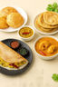 South Indian tiffin spread with masala dosa, puris, parottas, sambar, and chutneys on a beige background.